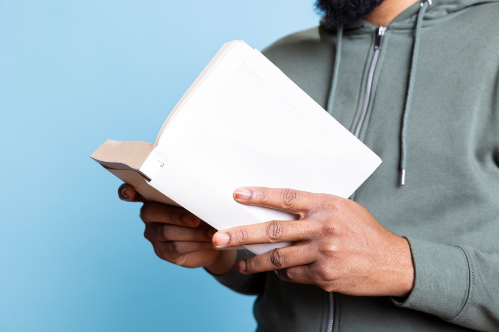 Person holding an open booklet with blank pages