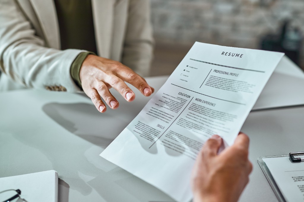 Professional reviewing a printed resume during a meeting